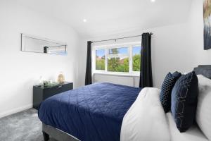 a bedroom with a blue bed and a window at Denham Close 3 Bedroom and 1 Bathroom Home in Uxbridge