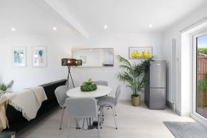 a living room with a table and a refrigerator at Denham Close 3 Bedroom and 1 Bathroom Home in Uxbridge
