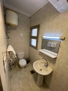 a bathroom with a white toilet and a sink at Houres Hotel in Cairo +93 photos
