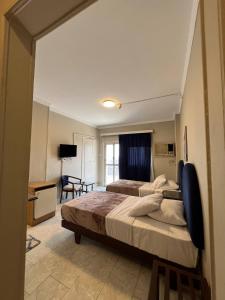 a large bedroom with two beds and a desk at Houres Hotel in Cairo