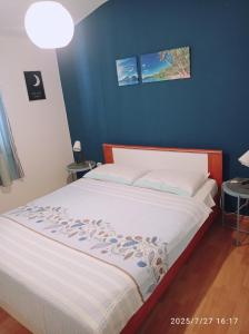 una camera da letto con un letto con una parete blu di Apartment Gogo a Umag (Umago)