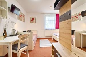 a kitchen and living room with a table and a desk at Penzion Šmolovy 238 in Havlickuv Brod