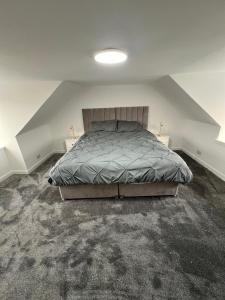 een slaapkamer met een bed en twee nachtkastjes bij Spacious 2 bed traditional cottage in Crieff