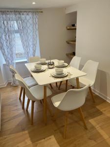 een eetkamer met een witte tafel en stoelen bij Spacious 2 bed traditional cottage in Crieff +6 foto's