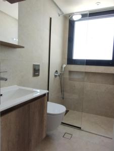 a bathroom with a toilet and a glass shower at Biliaba in Rhodes Town