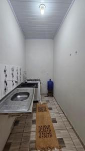a kitchen with a sink in the middle of a room at Casa Amarela no Centro in Barreirinhas