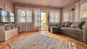a living room with a couch and a television at Ranniku Holiday House in Rannaküla