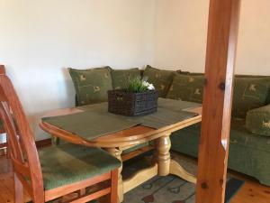 a table and a couch with a basket of flowers on it at Tipografov View Guest House in Veliko Tŭrnovo +6 photos