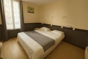 a bedroom with a large bed in a room at Hotel des Bains à 10 min de Paris in Maisons-Alfort