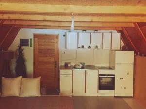 a small kitchen with white cabinets and a stove at Vikendica Tamara in Berane
