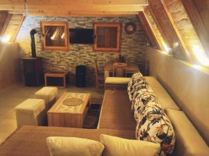 a living room with a long couch and a table at Vikendica Tamara in Berane
