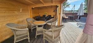 a patio with wicker chairs and a table on a deck at Rommi Kodumajutus in Pärnu