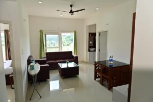 a living room with a couch and a table at Oasis Service Apartments in Mysore