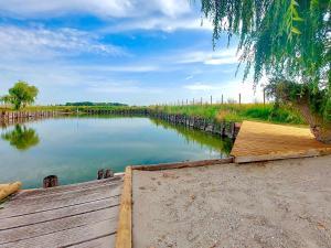a view of a river with a wooden dock at L'Observatoire in Hondschoote