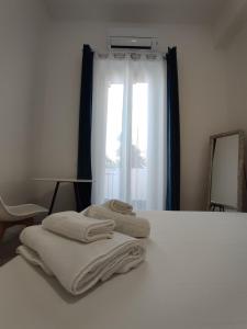 a bed with towels on it with a window at Petite Deva - Central loft with balcony in Cagliari +18 photos