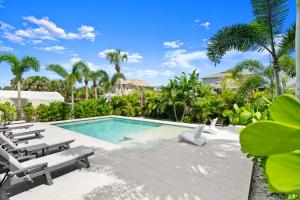 a swimming pool with lounge chairs and a resort at Luxury Home 6 Blocks From Flagler Ave & Beach Access Across the Street in New Smyrna Beach