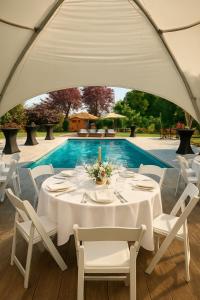 un tavolo apparecchiato per una cena sotto una tenda di La Maison de Maître, Piscine & Spa a Vitry-le-François