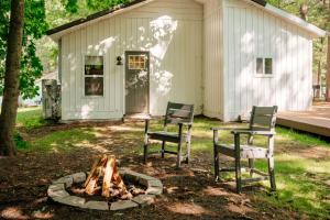 two chairs and a fire pit in front of a house at Arbutus Lake-King Suite-Pontoon Rentals in Traverse City