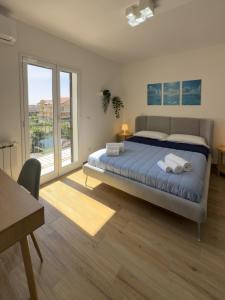a bedroom with a bed and a large window at Albachiara House in Calatabiano