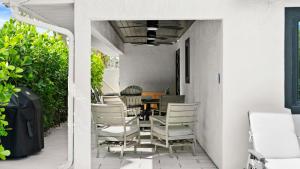 a patio with chairs and a table on a porch at Luxury Home 6 Blocks From Flagler Ave & Beach Access Across the Street in New Smyrna Beach