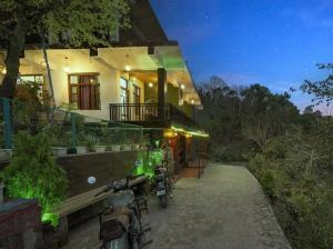 カソーリにあるHotel Elegant Dreamscape Kasauliの夜間、自転車が外に停まっている家