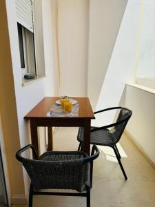 a table with two chairs and two glasses of orange juice at Polivios Apartment C in Térsa