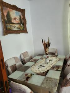 ein Esstisch mit Stühlen und ein Gemälde an der Wand in der Unterkunft Casa Nadia in Voineasa