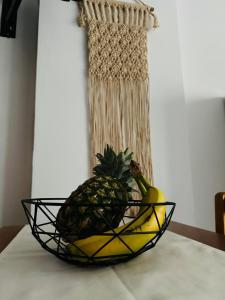 a bowl of fruit on a table with a pineapple and a banana at Polivios Apartment C in Térsa +4 photos