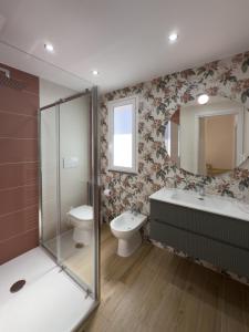 a bathroom with a toilet and a sink and a mirror at Albachiara House in Calatabiano +40 photos