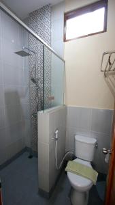a bathroom with a toilet and a glass shower at S5 Guest House Yogyakarta in Yogyakarta +44 photos