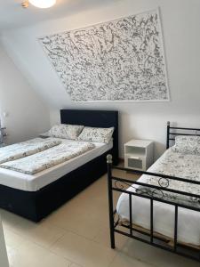 two beds in a room with a picture on the wall at Hotel Shelby Apartments in Garbsen