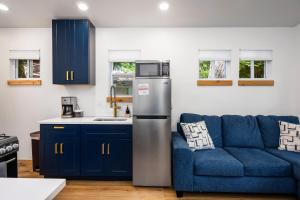 a kitchen with a refrigerator and a blue couch at Arbutus Lake Retreat in Traverse City