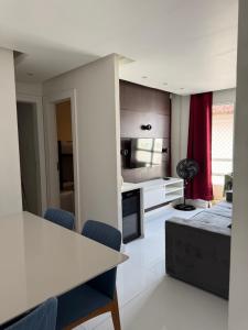 a kitchen and living room with a table and chairs at Apartamento aconchegante in Lauro de Freitas