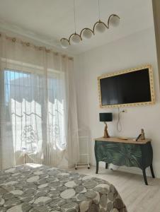 una camera da letto con un letto e una TV a parete di La Casa di Gabri Humanitas ForumAssago Milano centro a Rozzano