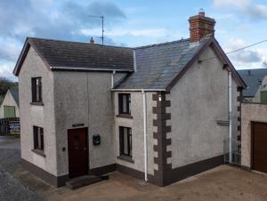 a small white house with a black roof at Killard Farm in Bellaghy