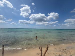 a man standing in the water at the beach at Charmant studio avec vue sur mer in Nabeul +5 photos