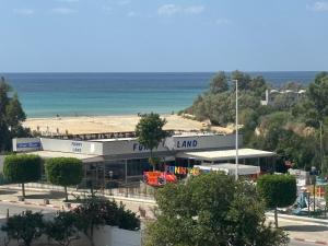 a building on the beach with the ocean in the background at Charmant studio avec vue sur mer in Nabeul