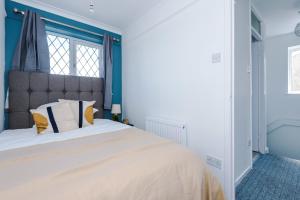 a bedroom with a large bed with blue walls at Family friendly 3-bed home free parking on site in Huddersfield
