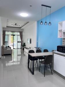 a kitchen and living room with a table and chairs at The Stay Inn in Kampong Rusamileh