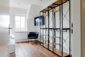 ein Zimmer mit einem schwarzen Bücherregal und einem schwarzen Stuhl in der Unterkunft janu-homes - 3 Zimmer Apartment - 7 Betten, Lahnblick vom Römer in Runkel