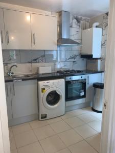 una cocina con lavadora y fregadero en Ellison House, en Londres