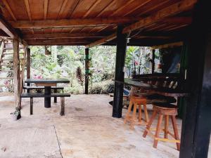 a patio with a table and two stools under a roof at Cabins river blue in Rio Celeste