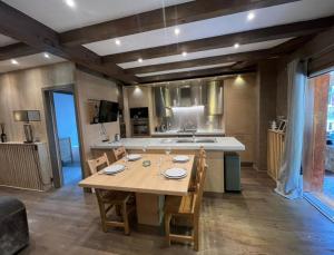 a large kitchen with a wooden table and chairs at Le Château - Appartement Génépi in Morzine