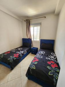 a bedroom with two beds and a window at Élégant appartement moderne au centre d'Oujda in Oujda