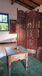 a room with a wooden table and a room with a wall at Casa Encantada in Paraty