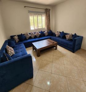 a living room with blue couches and a coffee table at Élégant appartement moderne au centre d'Oujda in Oujda