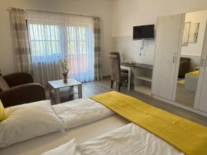 ein Hotelzimmer mit einem Bett und einem Wohnzimmer in der Unterkunft Ferienwohnung Thermenauszeit - mit Balkon und Bademantelgang in Bad Griesbach