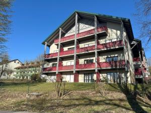 ein großes Gebäude mit roten Balkonen an der Seite in der Unterkunft Ferienwohnung Thermenauszeit - mit Balkon und Bademantelgang in Bad Griesbach + 3 Fotos