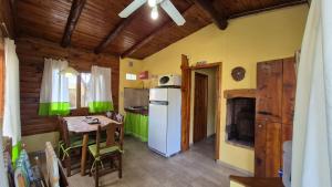 a kitchen with a table and a white refrigerator at Alto de Balcón in Tanti