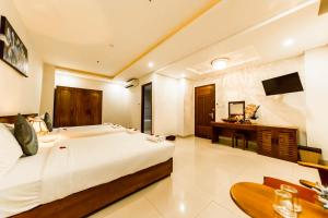 a bedroom with a large white bed and a desk at Kiên Cường 2 Hotel in Da Nang